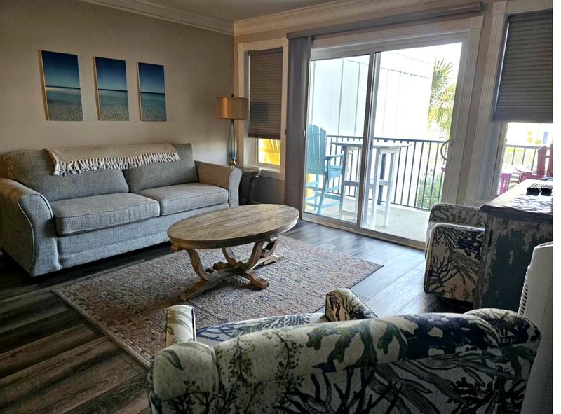 Living room with balcony and coastal decor - guest ready property